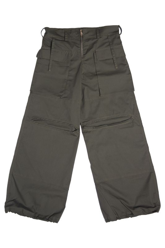 “Oliwkowe cargo baggy spodnie dla tancerzy, widok z przodu, z szerokimi nogawkami, licznymi kieszeniami i elastycznymi ściągaczami u dołu.”