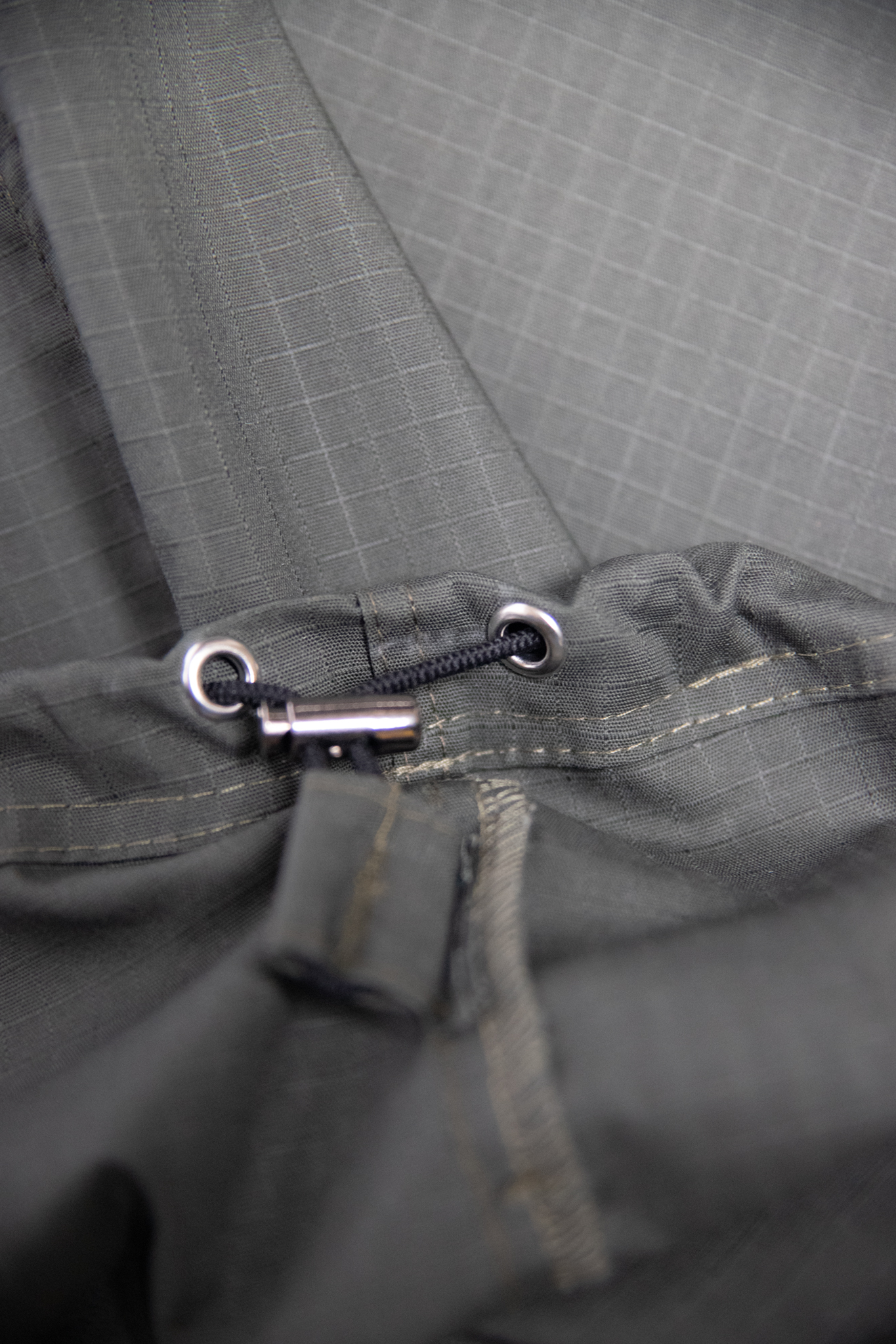 “Zbliżenie na dolny ściągacz i wykończenie oliwkowych cargo baggy spodni dla tancerzy, pokazujące detale szwów i mechanizm regulacji.”