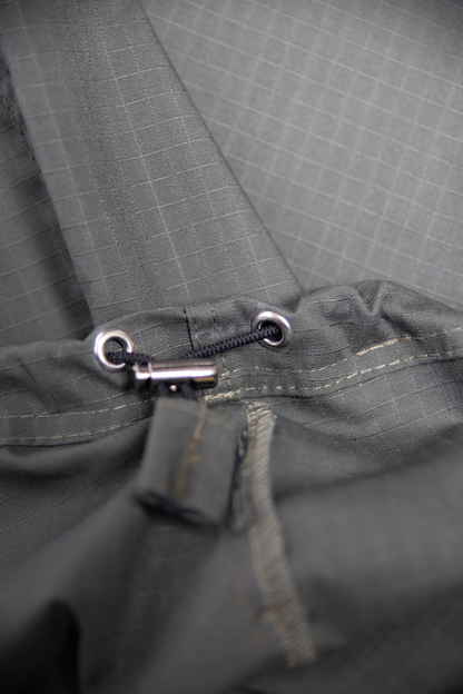 “Zbliżenie na dolny ściągacz i wykończenie oliwkowych cargo baggy spodni dla tancerzy, pokazujące detale szwów i mechanizm regulacji.”