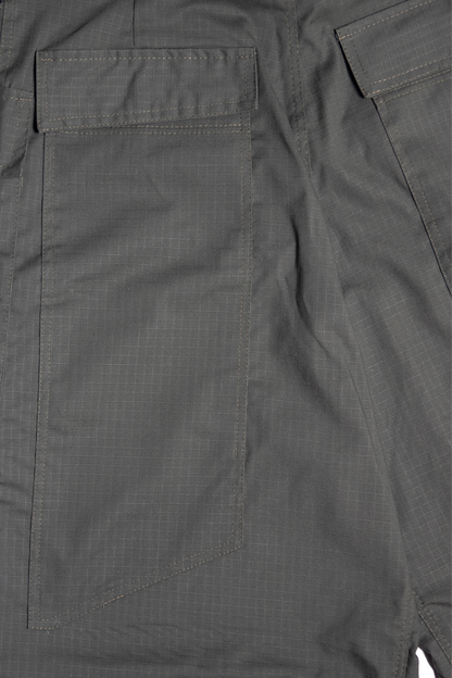 “Zbliżenie tylnej kieszeni oliwkowych cargo baggy spodni dla tancerzy, z wyraźną fakturą materiału i przeszyciami.”