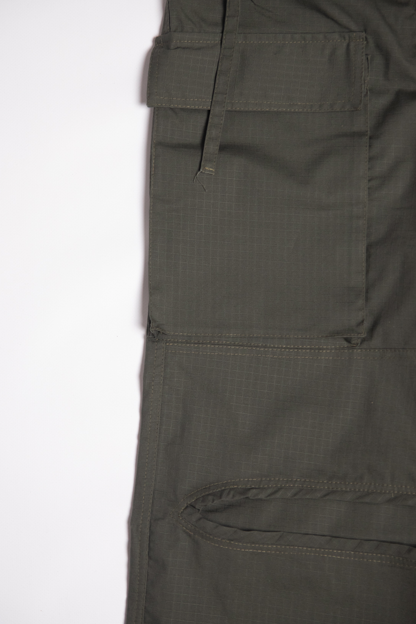 “Detal cargo baggy spodni dla tancerzy w kolorze oliwkowym, z dużą boczną kieszenią i widoczną strukturą materiału ripstop.”