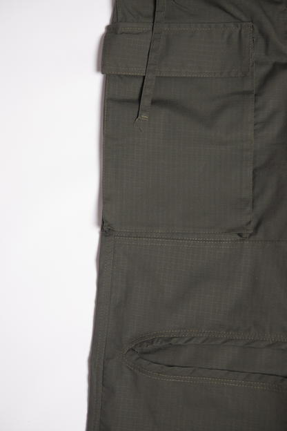 “Detal cargo baggy spodni dla tancerzy w kolorze oliwkowym, z dużą boczną kieszenią i widoczną strukturą materiału ripstop.”